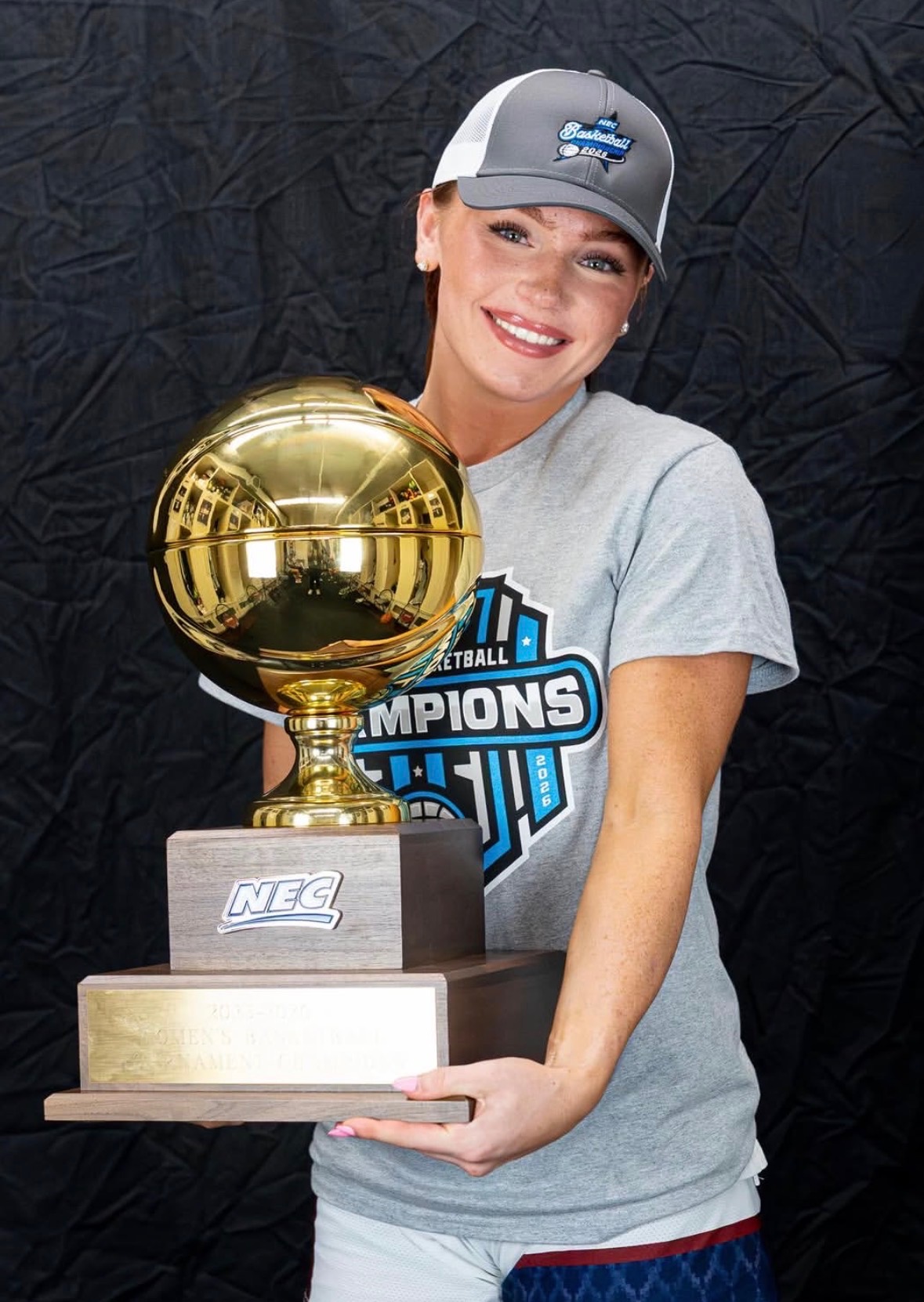 Kailee holding a basketball championship trophy